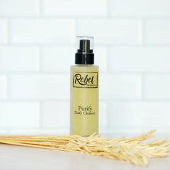 Daily cleanser bottle with black pump, Rebel Skincare label, and yellow liquid inside