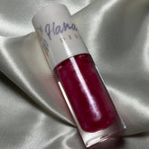 Lip gloss tube with red gloss, white cap, and "Hana Design" text on white satin fabric background