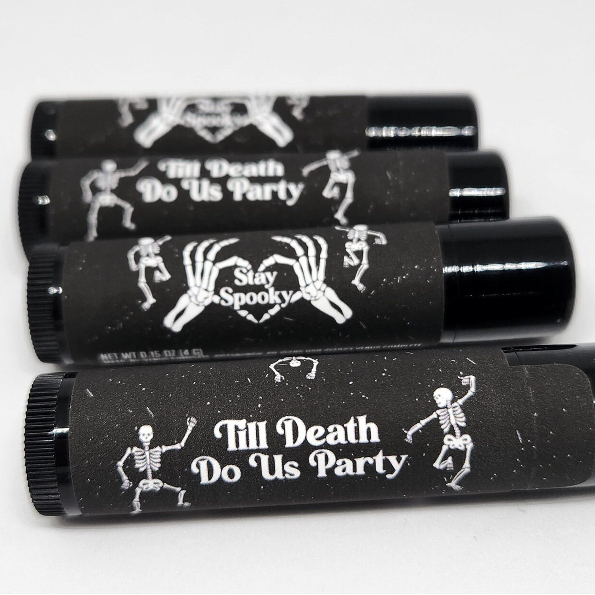 Lip balm, black tubes with white skeleton design and text, for Halloween party favors