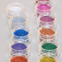 Hand applying shimmering silver glitter eyeshadow from a sifter jar onto eyelid