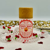 Lip balm tube with paper top and pink striped label, "Cupid's Arrow" text, surrounded by beads