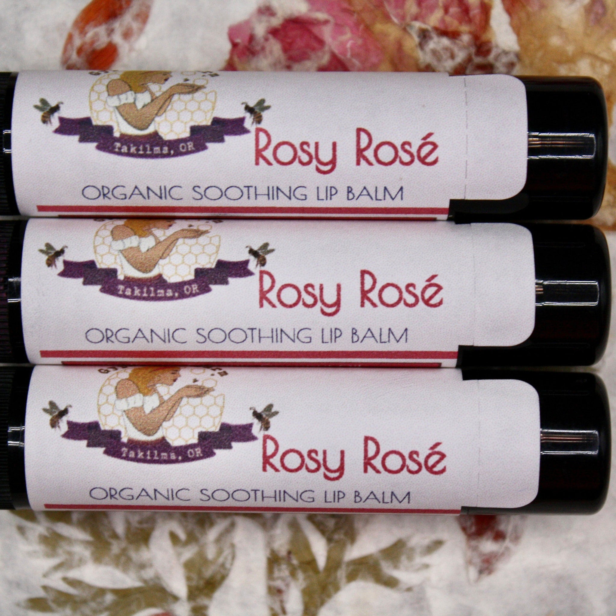 Lip balm tubes with white labels, red text "Rosy Rosé", and black tubes, GypsyBeeFarm brand