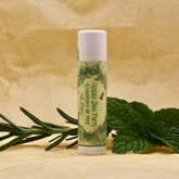 Lip Balm tube with white cap and label, Gypsy Bee Farm branding, and green leaves beside it