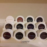 Front view of ColourPop eyeshadow display stand with multiple circular pans in assorted matte and shimmer shades
