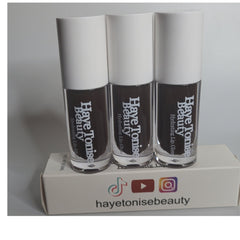 Lip gloss tubes with white caps, brown gloss, and Haye Tonise Beauty branding on a white box