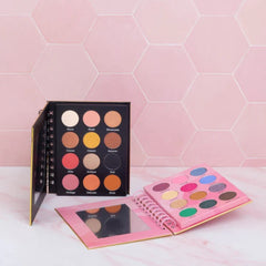 Eyeshadow palettes with various colors, black and pink cases, and a mirror for makeup application