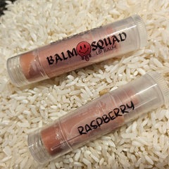 Lip balm tubes with pink tint and clear plastic, "Balm Squad" and "Raspberry" text visible