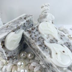 Soap bars with white and brown speckled pattern, white floral design, and decorative pearls