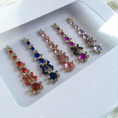 Jeweled accessories with red, blue, pink, purple and gold accents, in a white box, for decorative use