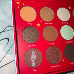 Eyeshadow palette with red case, various colors, and names on the palette