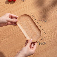 Wooden oval tray, light brown wood grain, held by hands, dimensions shown