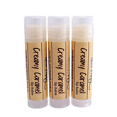 Lip balm tubes with beige labels, clear caps, and "Creamy Caramel" text by BluePoppyBath