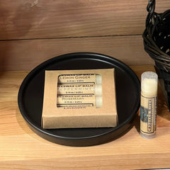 Lip balm set in a brown cardboard box with black tray and Crooked River label, wooden background