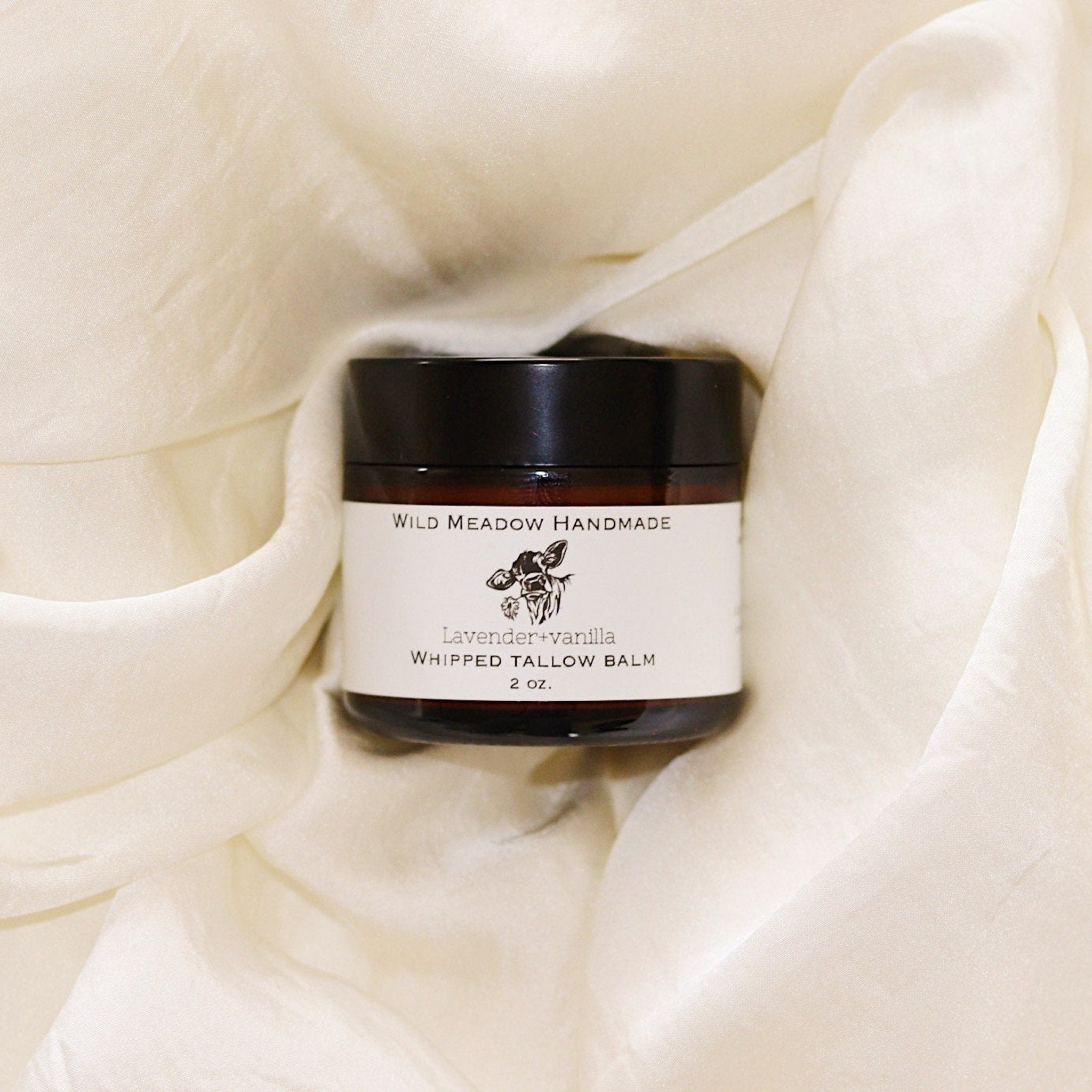 White ceramic jar of whipped tallow balm with gold lid and minimalist label, showcasing rich texture