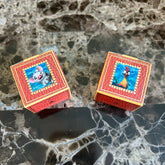 Eye shadow boxes with red leather-look texture and Disney character images on marble surface