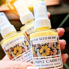 Eye serum bottles with yellow liquid, white spray tops, and floral label design, Leaf Seed Berry brand visible
