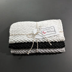 Black and white cotton face cloths gently pressed against skin during cleansing routine