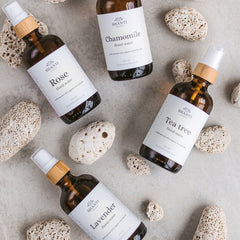 Hand spritzing rose lavender toner onto clean face with eyes closed, showcasing refreshing mist application