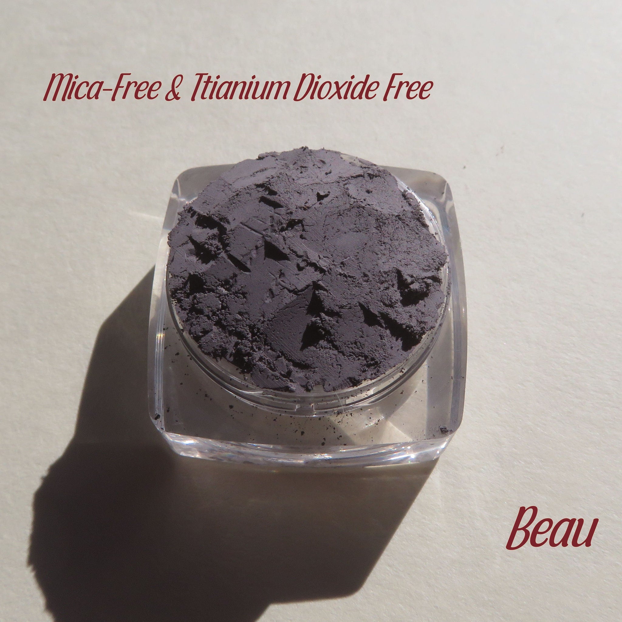 Eye shadow, matte gray powder in clear jar, Beau brand name visible