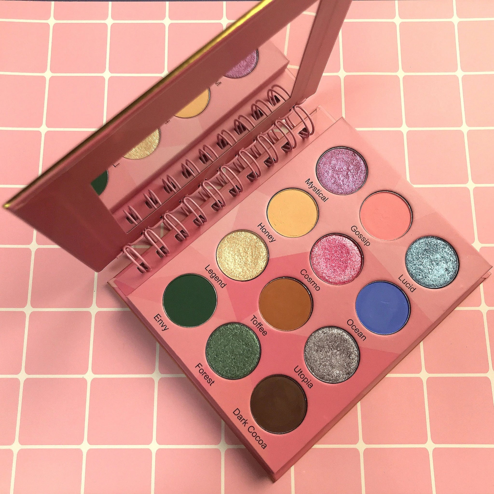 Eyeshadow palette with pink case, mirror, and 12 colorful eyeshadows