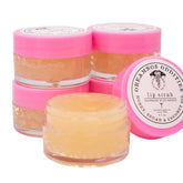 Glass jar of natural lip scrub with creamy texture and minimalist beige label