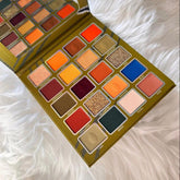 Eyeshadow palette with multiple colorful shades, Prolux brand, on a white fluffy surface