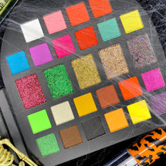 Eyeshadow palette with multiple colors, glitter, and matte finishes for makeup application