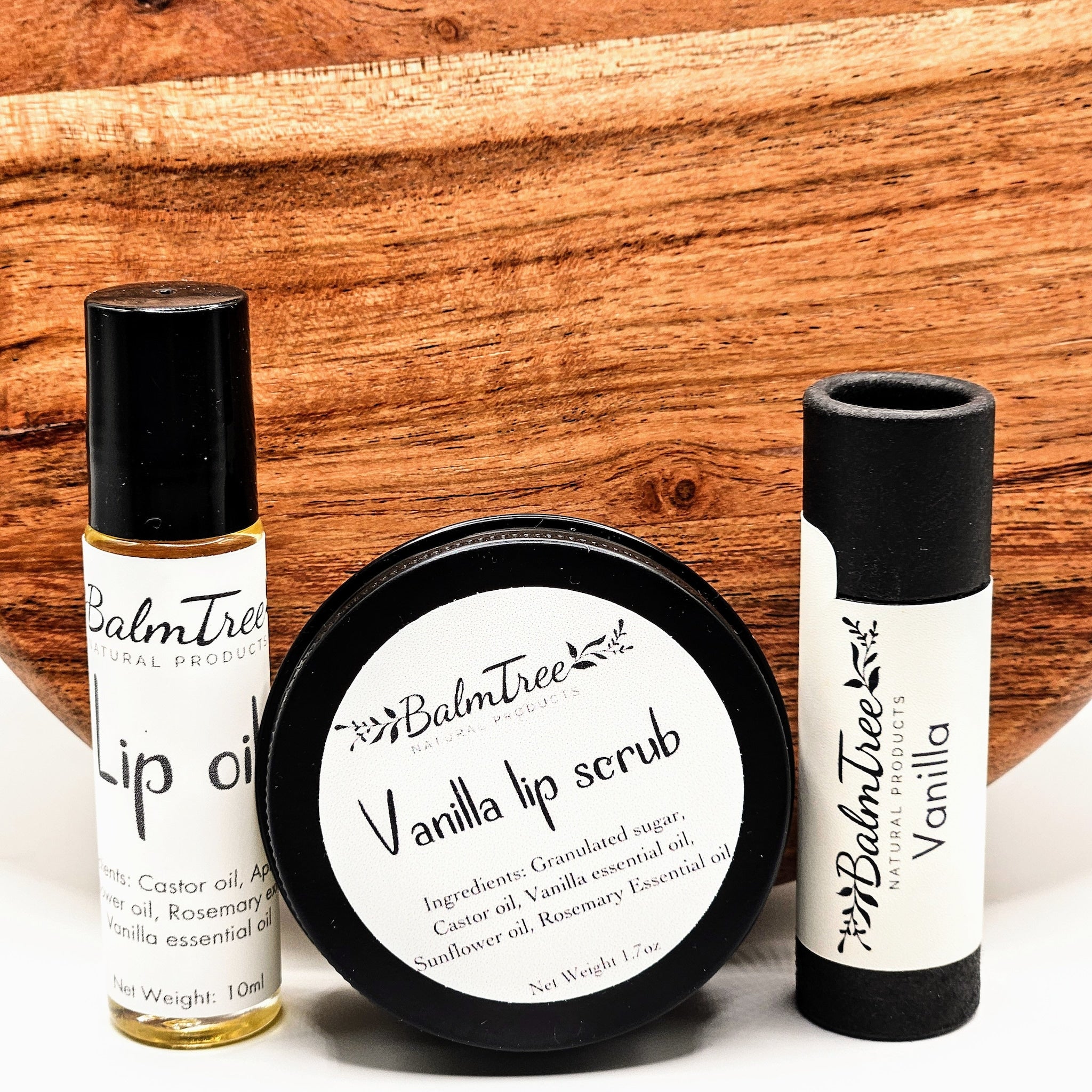 Lip balm set with black and white labels, and wooden background, BalmTree brand