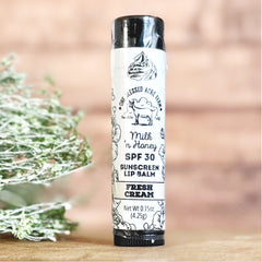 Sunscreen lip balm tube with white label, black text, and One Blessed Acre Farm branding