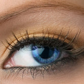 Eye makeup, close-up of eye with blue iris, long dark lashes, and peach eyeshadow applied
