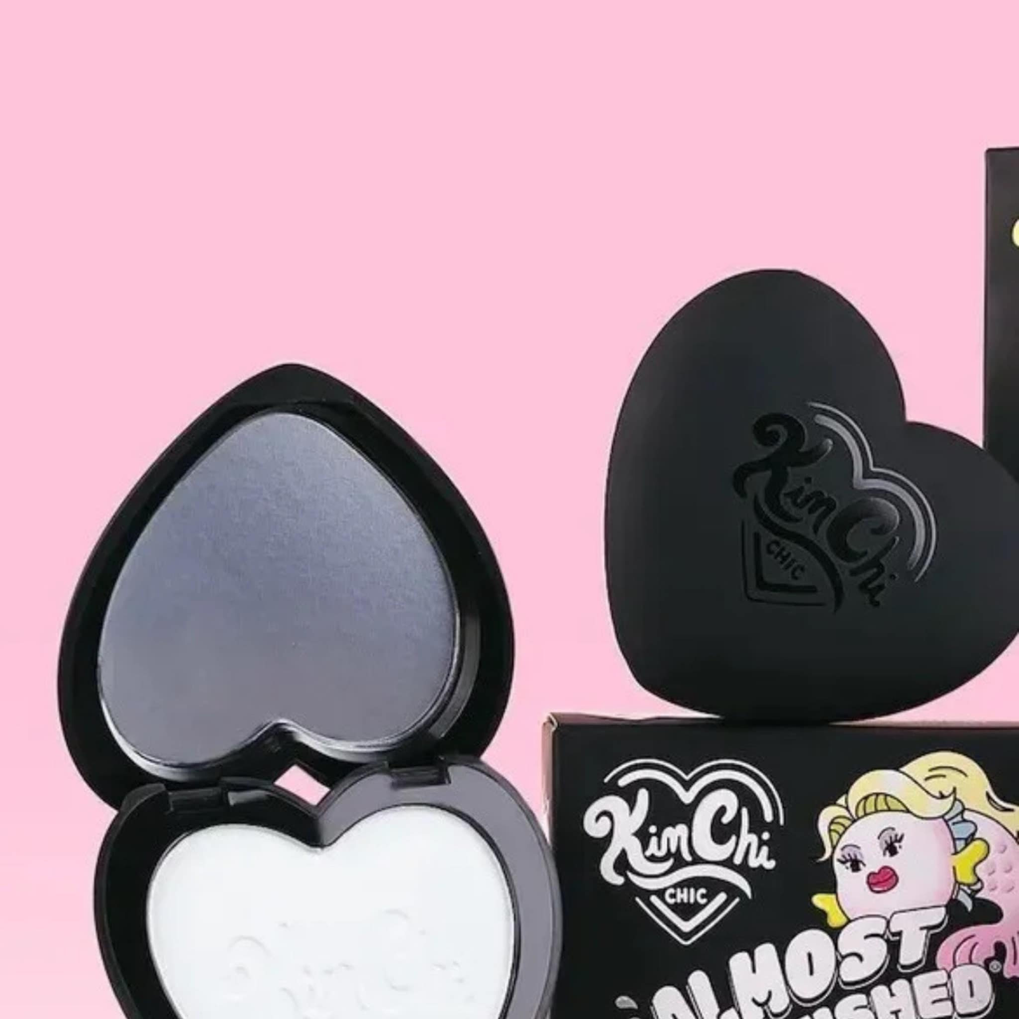Face powder compact with heart shape, black case, and white powder inside