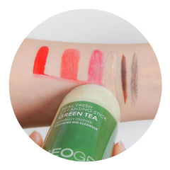 Lipstick swatches in red, pink, and brown with green and white cleansing stick, on skin