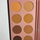Powder palette with multiple shades of orange and brown in a pink compact