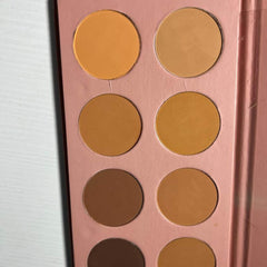 Powder palette with multiple shades of orange and brown in a pink compact