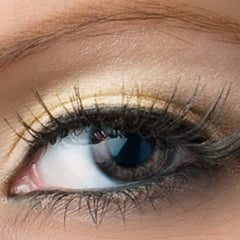 Eye makeup with gold eyeshadow, black mascara, and brown eye color detail