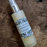 Rosewater toner bottle, frosted glass, silver pump, Ageless Botanicals label, on wood surface