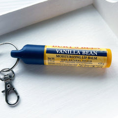 Lip balm tube with blue and yellow sections, Burt's Bees branding, and a silver keychain