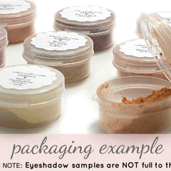 Eyeshadow samples in clear plastic jars with white labels, various shades of powder visible