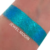 Eyeshadow swatch with Jewel Moon text, showing blue-green chrome color and textured finish on skin