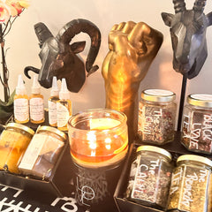 Body care products with clear glass bottles, "The Good Black Man" label, and amber liquid inside, displayed on a shelf