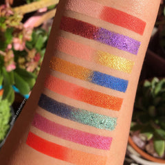 Eyeshadow swatches with various colors and textures on arm, with @makeupbykarmenn watermark