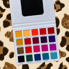 Eyeshadow palette with multiple colors, square pans, and a white compact for makeup application.