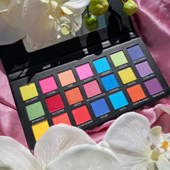 Eyeshadow palette with colorful shades, black compact, and floral background