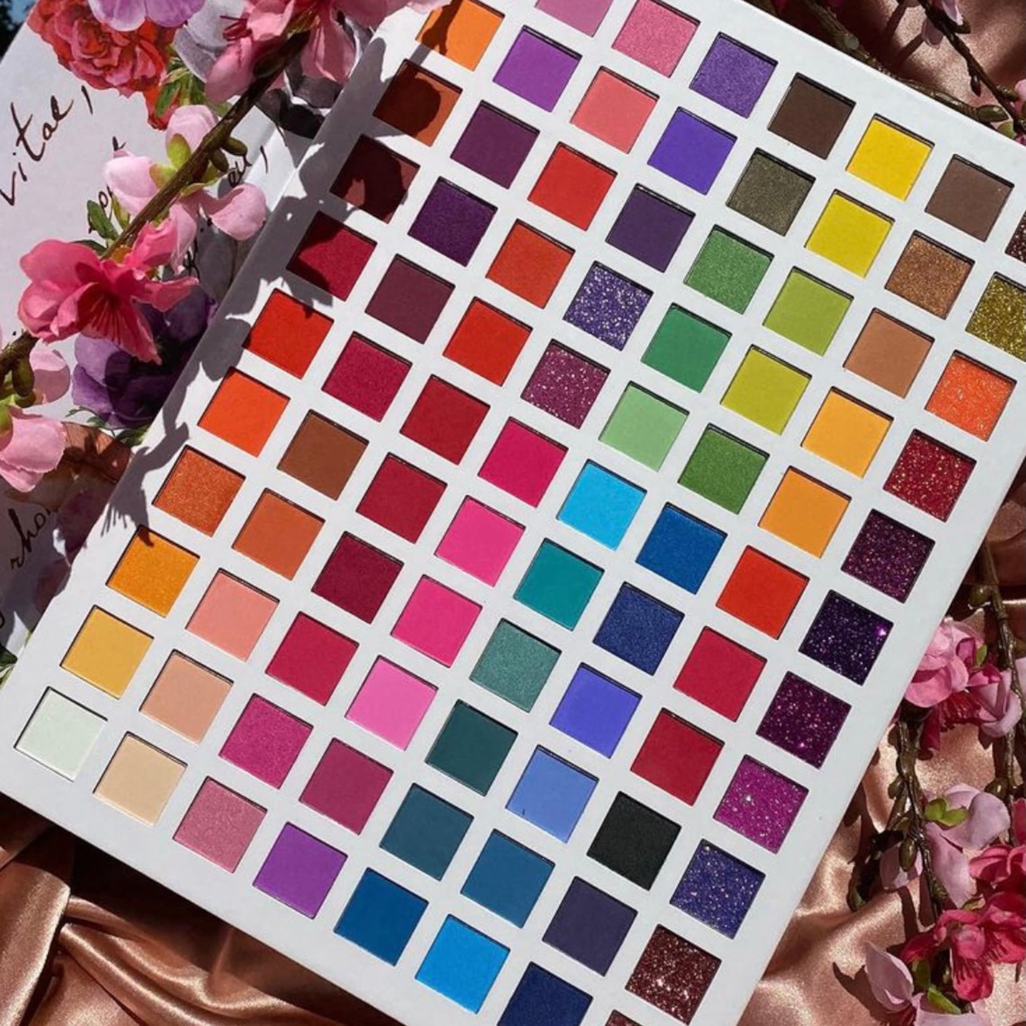 Eyeshadow palette with multiple colorful squares, Prolux brand, on white background
