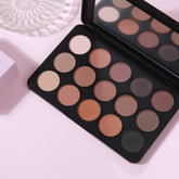 Eyeshadow palette with multiple shades, black compact, and mirror reflection