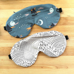 Sleep masks with teal and white patterned fabric and black elastic band for sleeping