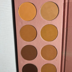 Eyeshadow palette with multiple shades of brown and tan in a pink case