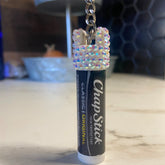 Chapstick cap keychain with iridescent rhinestone embellishments and silver chain, holding ChapStick tube