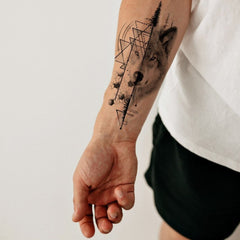 Side view of wolf forest temporary tattoo set showing skin-safe animal designs on matte black backing card