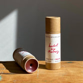 Lip balm tubes in brown cardboard with red text, Priya Means Love brand